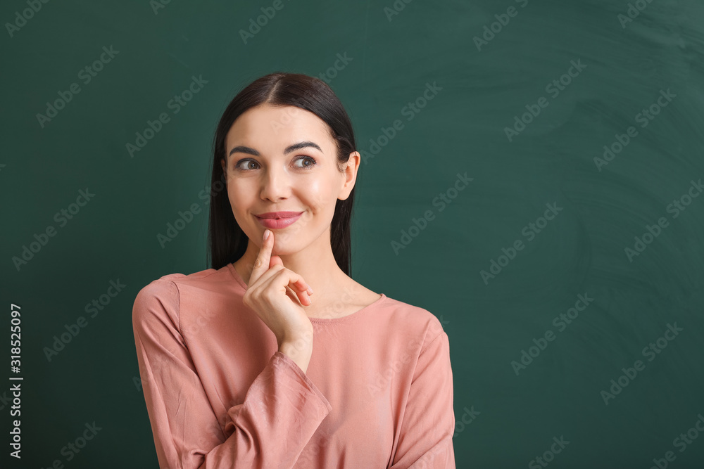 Thoughtful female teacher near blackboard in classroom