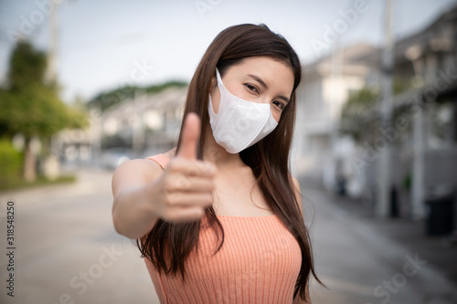 Cuadros en Lienzo Woman wearing protective mask, showing thumbs up.