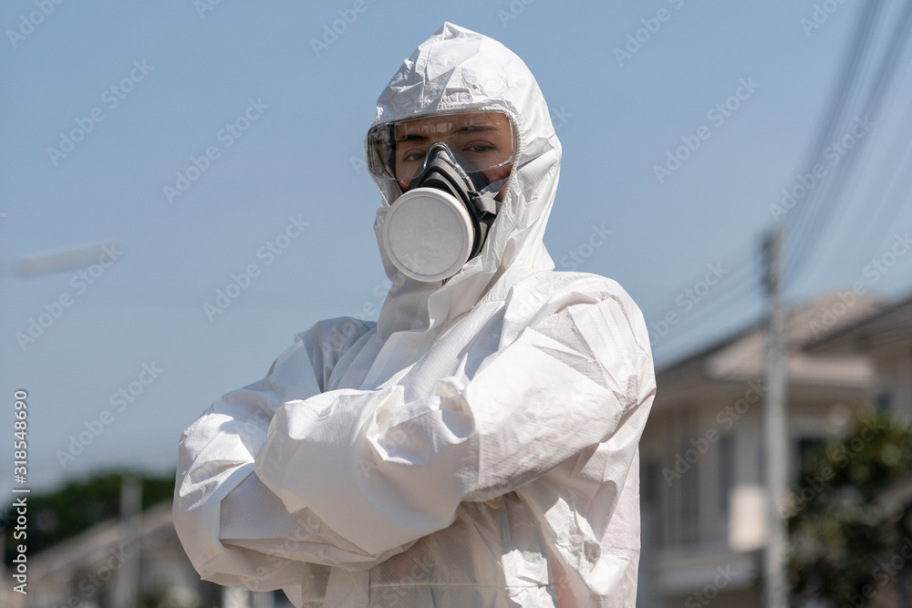 Woman wearing gloves with biohazard chemical protective suit and mask. She crossed her arms with unhappy face. - obrazy, fototapety, plakaty 