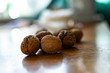 © Анна Иванова - Solid and embossed brown-shelled walnuts lie on a wooden table, illuminated by the harsh sunlight
