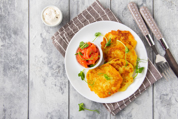 Canvas Print - Fried potato pancakes with salmon and sour cream, fritter, roesti, golden crispy crust. Traditional delicious food