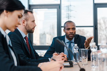 selective focus of handsome african american representative talking near diplomats