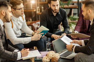 Canvas Print - business coworking of young caucasian bearded men in office gathered to discuss business ideas, share experiences and opinions, successful cooperation of enthusiastic business people