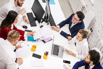 Wall Mural - top view on business meeting of caucasian young people, successful team gathered in office, professional managers in formal wear. Business people concept