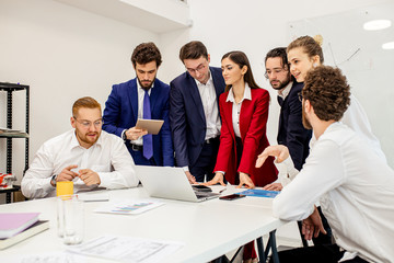 Wall Mural - business coworking in office, young business people enjoy working together in modern office, everyone in stylish formal wear, help each other and communicate, share experience