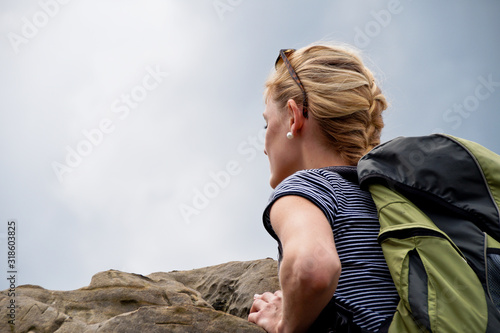 Fotografía Low Angle View Of Young Woman Leaning On Rock Against Sky