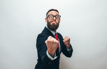 Crazy businessman with beard in trendy formal suit ready for fight over gray background