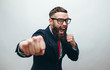 © San4ezz007 - Crazy businessman with beard in trendy formal suit ready for fight over gray background