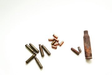 empty cartridges for firearms and pistol cartridges next to old cartridges on a white background