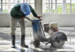 Workers using machine cutting concrete for expansion and isolation joint of slab on grade in construction buiding