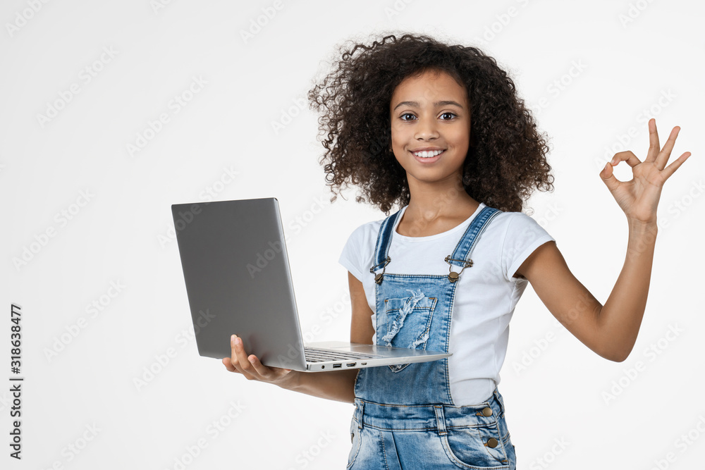Little african girl holding laptop with OK sign isolated on white ...