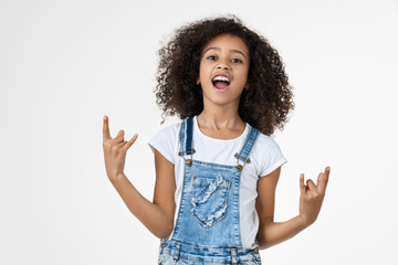 Happy little african girl kid showing rock gesture isolated over white wall background