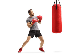 Canvas Print - Young man exercising box with a red punching bag