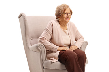 Poster - Senior woman sitting in an armchair thinking