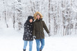 © satura_ - Happy loving couple having fun outdoors in snow park. Winter vacation