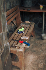 an old hammer, a hand saw, protective gloves and a round pine beam with sawdust on a bench. Wooden stand for food for the master class. DIY concept.