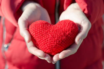 Girl holds a red heart. Valentine's Day Gift. Mother love concept