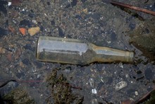 High Angle Shot Of A Dirty Glass Bottle Thrown On The Ground