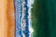 Aerial view of a wave breaking at the shore of the Comporta Beach in Portugal.