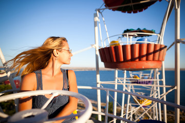 Young happy mother outdoors on Ferris wheel