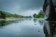 © zef art - Detail of the rear wheel of a car driving in the rain on a wet road. Aquaplaning in road traffic.