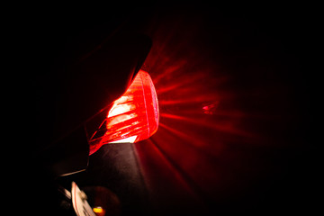 Red tail break light of a two wheeler sprayed with water droplets and the reflecting showers of water