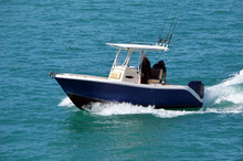 Two Fishermen Aboard Aa Small Blue And White Sport Fishing Boat Powered By A Single Outboard Engine Slowly Cruising On The Florida Intra-Coastal Waterway