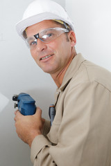 man drilling the wall with drill perforator