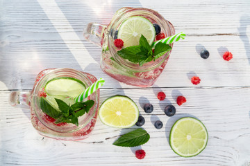 Wall Mural - Homemade cold summer cocktail with mineral water, mint, lime, berry juice and fresh berries, top view