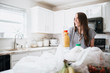 © MeganBetteridge - Lifestyle of women unloading her groceries at home in a white kitchen