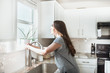 © MeganBetteridge - Women holding indoor plant in a white kitchen