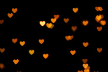 Black Background With Bright Warm Heart Shaped Bokeh Lights. Holiday, Valentines Day Background. Ideal To Layer With Any Design. Horizontal