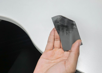 close up dirty oil clear facial sheet in man hand after working