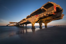 Old Broken Bridge Over The Sea Under A Clear Blue Sky