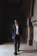 © Margo Basarab - Elegant smiling handsome groom in blue suit posing on the background of old castle
