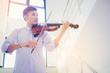 © Panumas - A musician man is practicing the violin playing with the melodiousness at stairway. Selected focus.