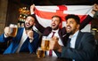 Business men in pub cheering for a sporting event