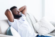 Relaxed african american man resting at home on sofa