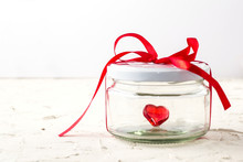 Little Red Heart In Glass Jar With Ribbon On White Background