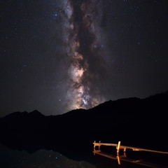 Wall Mural - the night sky and the milky way. silhouettes of mountains, mountain lake, wooden bridge. starry sky,