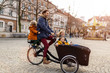 © pikselstock - Young family enjoying spending time together, riding in a cargo bicycle