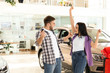 © New Africa - Happy couple with car key in modern auto dealership