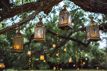 Evening Wedding Ceremony With A Lot Of Vintage Lanterns, Lamps, Candles. Unusual Outdoor Ceremony Decoration. Beautiful Garden Party Concept.