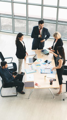 vertical business background of group of businesspeople around meeting table and having business discussion in office