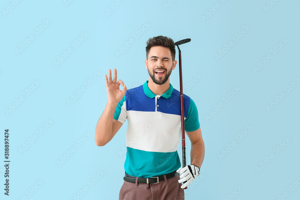 Handsome male golfer showing OK on color background