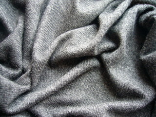 The texture of the fabric closeup. Mixed gray knit fabric.