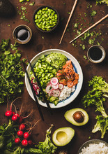 Healthy Lunch, Dinner. Flat-lay Of Salmon Poke Bowl Or Sushi Bowl With Various Vegetables, Greens, Sushi Rice, Soy Sauce Over Rusty Table Background, Top View. Traditional Hawaiian, Clean Eating Food