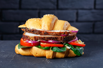 Poster - Croissant sandwich with pork on a table