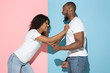 © master1305 - Screaming, angry. Young emotional man and woman in casual clothes on pink and blue bicolored background. Concept of human emotions, facial expession, relations, ad. Beautiful african-american couple.