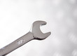 Wrench on shiny metallic silver background